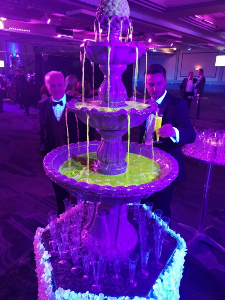 UV glow in the dark cocktail fountain serving illuminated cocktails at an event as a drinks fountain