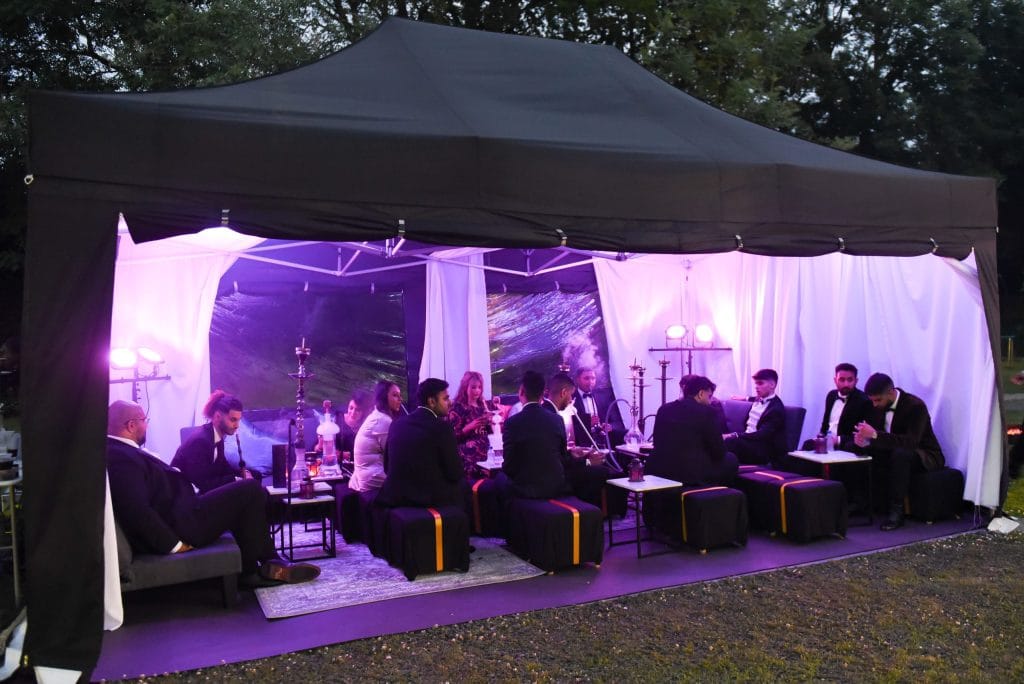Shisha tent hire uplit at night with guests seated inside at a Mr Flavour event