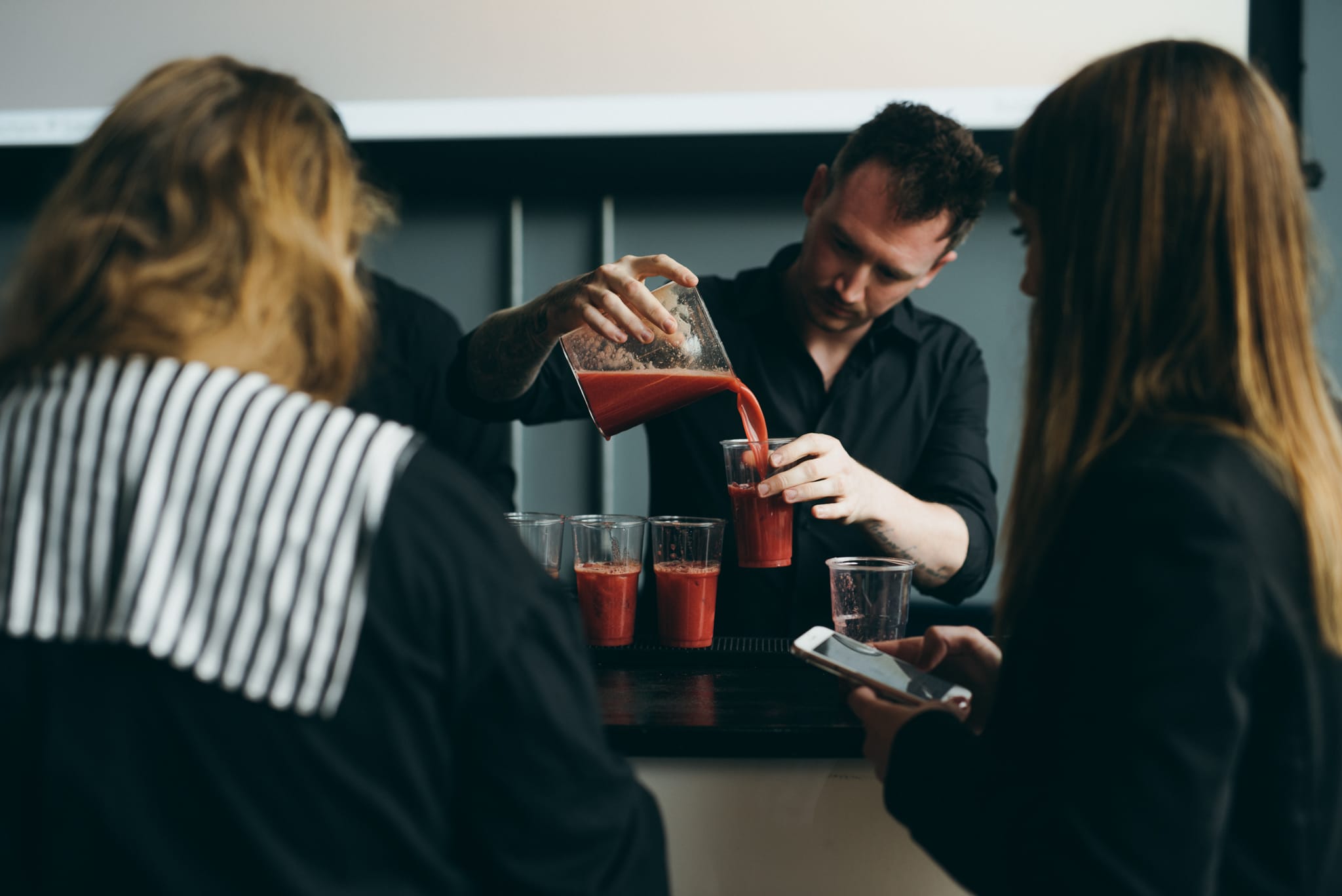 Juice bar hire with a professional bartender pouring freshly made juice at an event