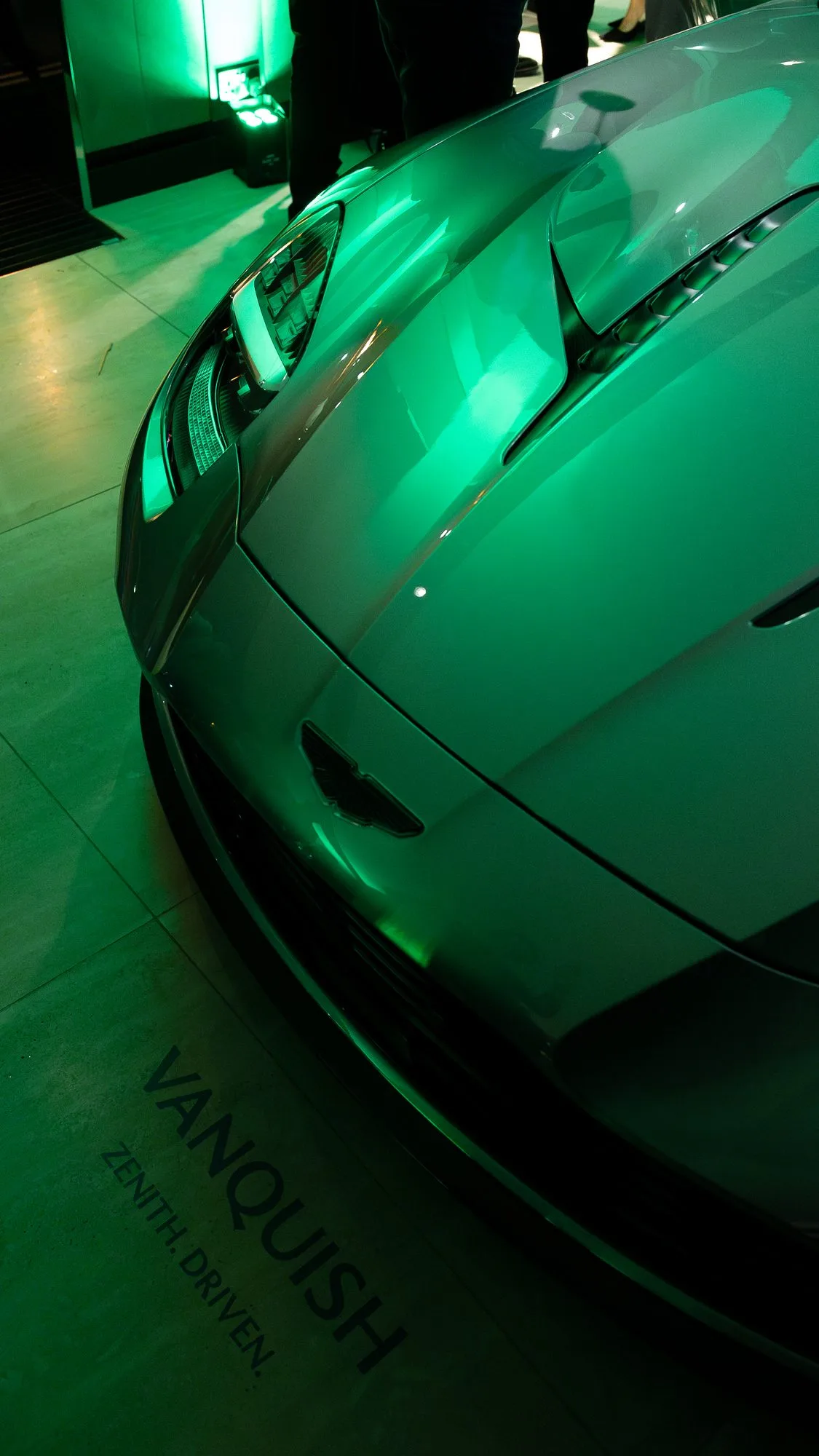 The new Aston Martin Vanquish lit in green at the Mayfair launch, the Vanquish name visible on the bodywork