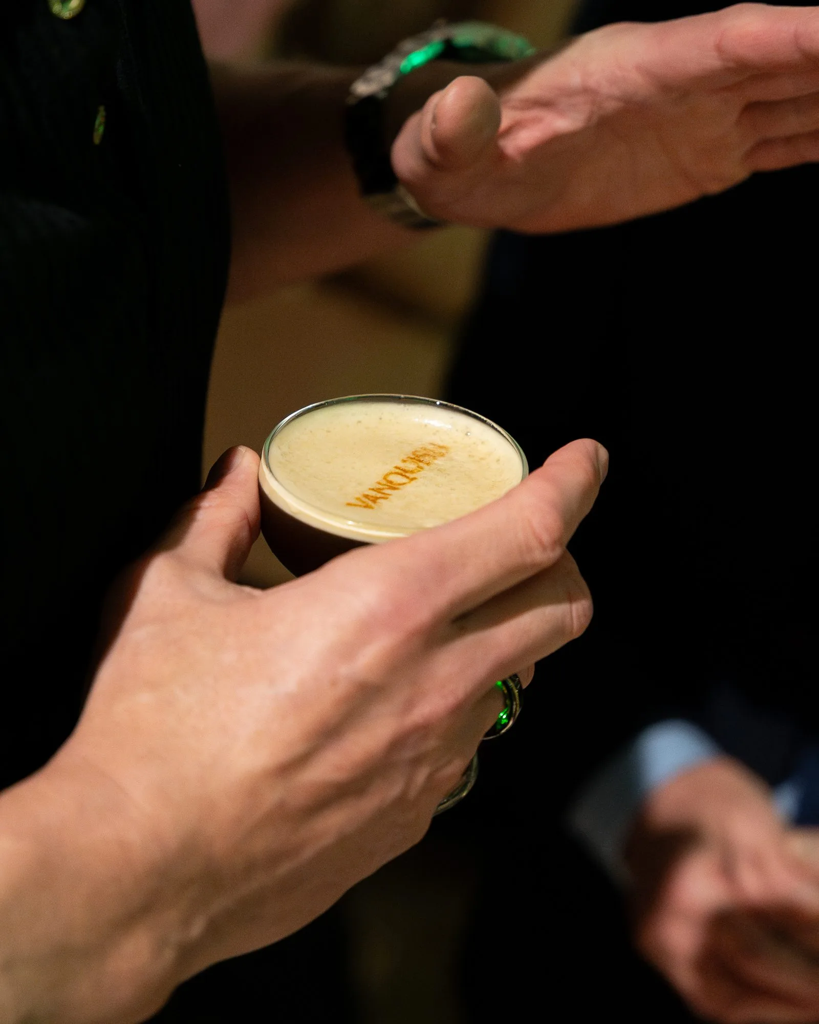 A branded Aston Martin espresso martini held in hand at the launch, the marque's logo finished on the foam