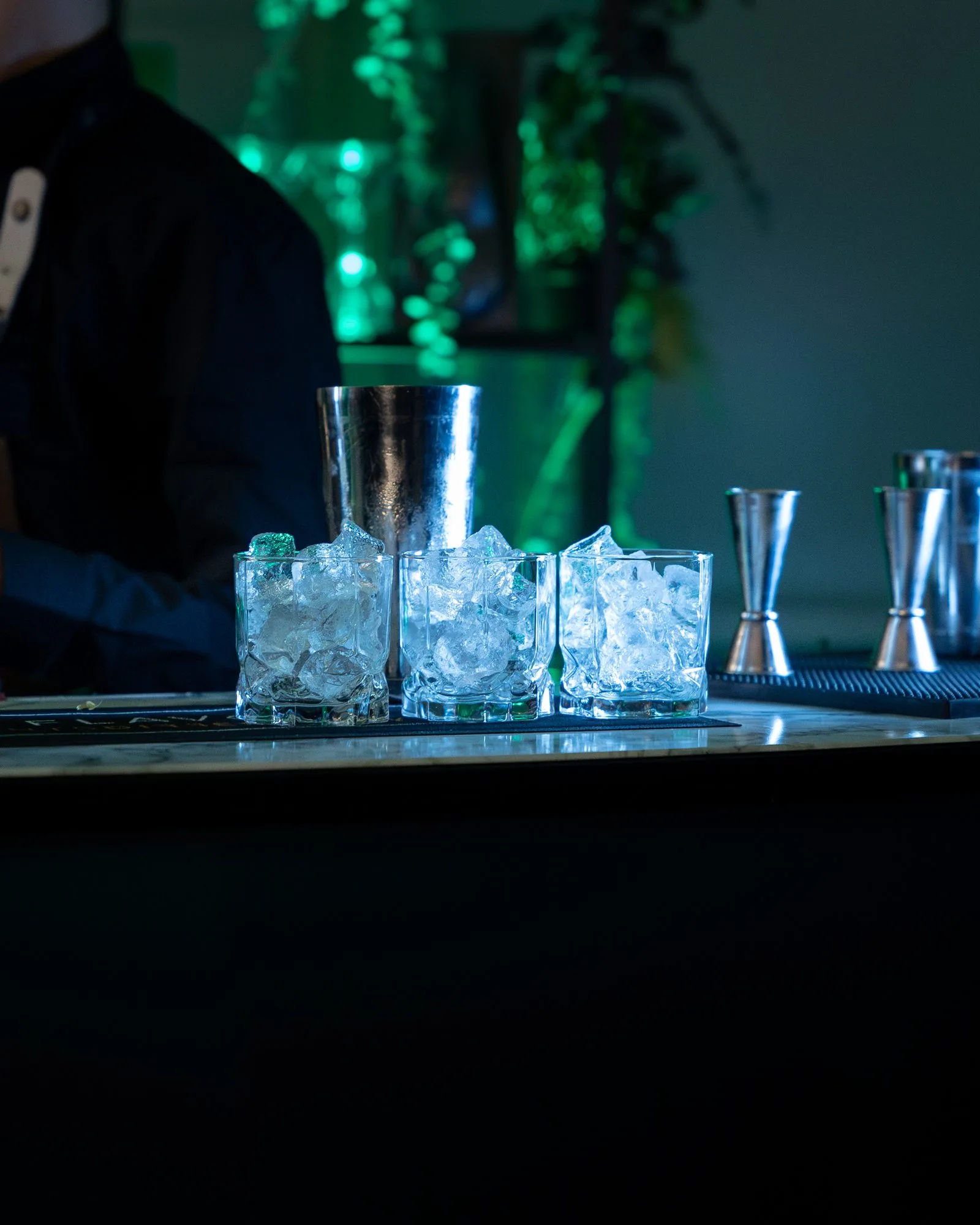 Cocktail glasses, ice and bar tools set up on the Mr Flavour bar ready for service at the Aston Martin launch