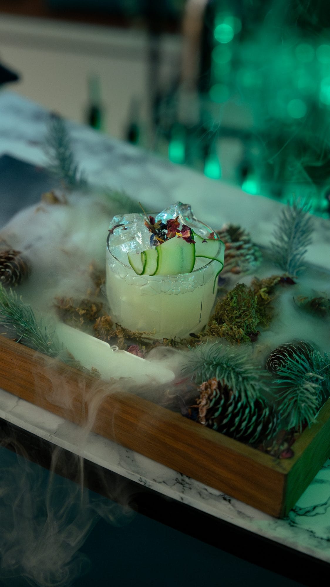 A signature green cocktail created for the Aston Martin launch, garnished and styled on a botanical display