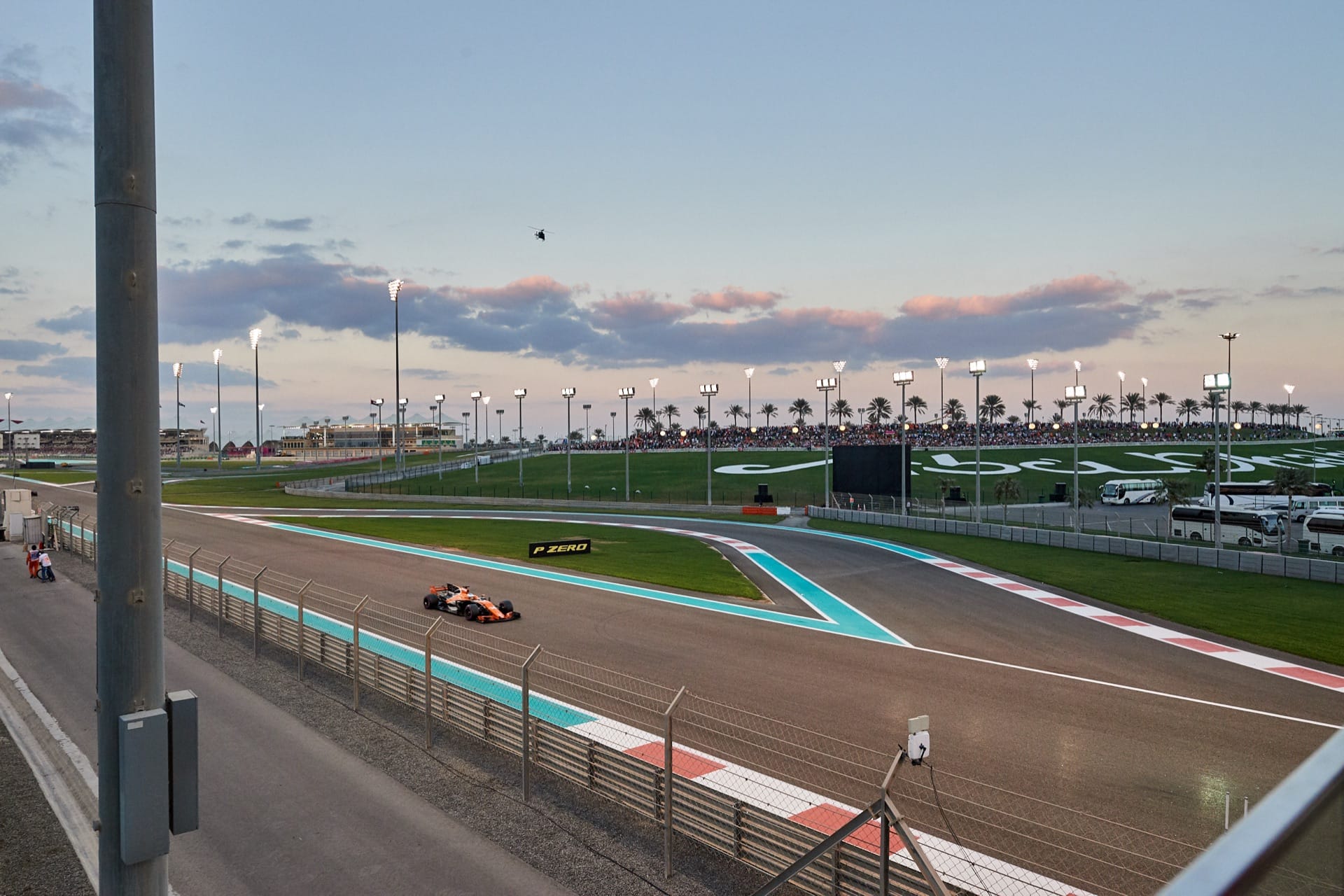 A Formula One car on the Yas Marina Circuit at dusk during the Abu Dhabi Grand Prix
