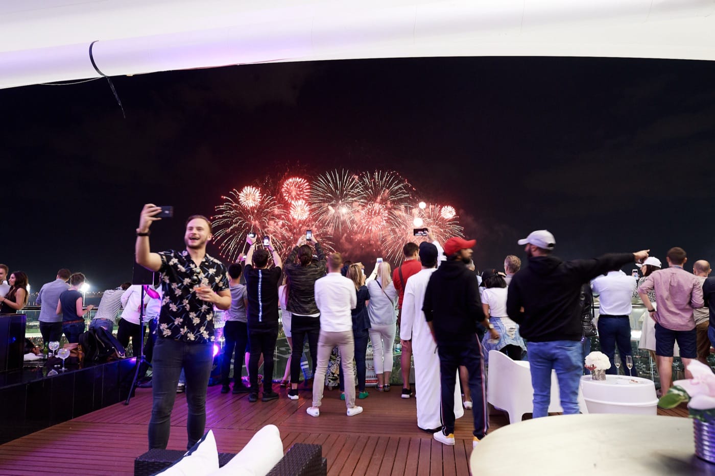 Guests watching the closing fireworks over the Yas Marina Circuit with drinks in hand at the Abu Dhabi Grand Prix