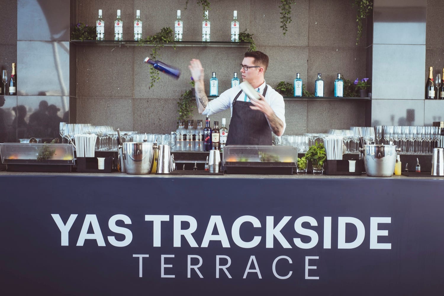 Mr Flavour flair bartender performing behind the Yas Trackside Terrace bar at the Abu Dhabi Grand Prix