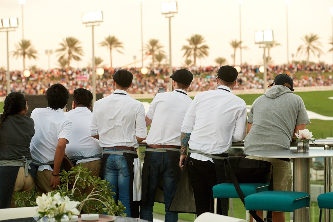 Mr Flavour hospitality team on a Yas Marina suite balcony overlooking the circuit at the Abu Dhabi Grand Prix