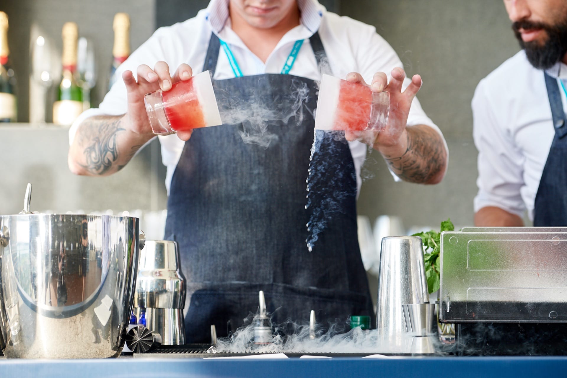 A Mr Flavour mixologist preparing a liquid nitrogen cocktail with billowing vapour on a VIP bar at the Abu Dhabi Grand Prix